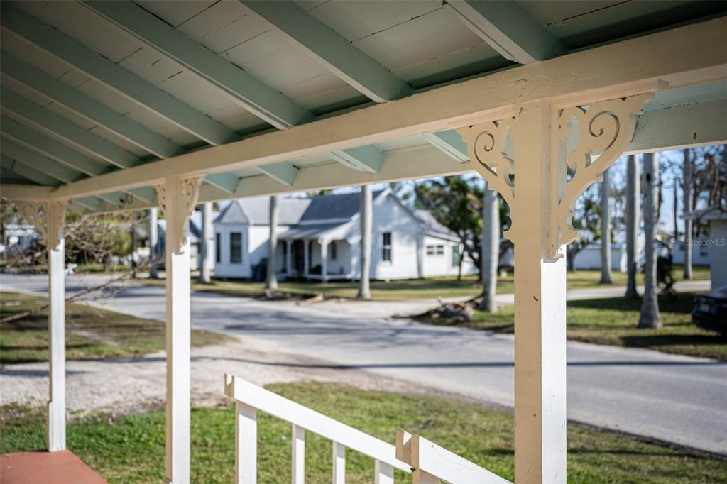 A view from a covered porch looking out toward a white house across the street — 12007 45TH AVENUE W, CORTEZ, FL