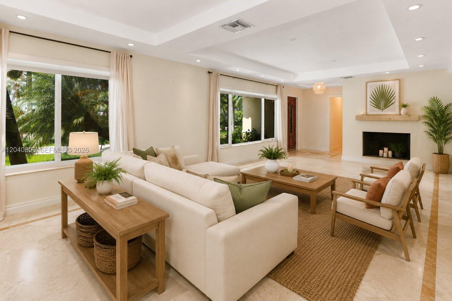A bright living room features a white sofa, wooden coffee table, and a fireplace — 1030 Polk St, Hollywood FL 33019, HOLLYWOOD, FL
