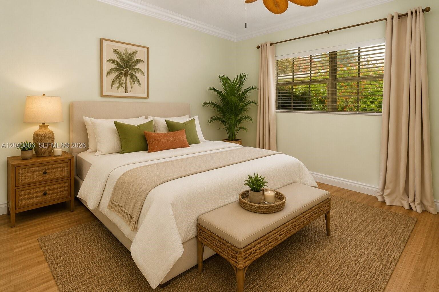 A bedroom features a bed with green and orange pillows, a bench, and a window — 1030 Polk St, Hollywood FL 33019, HOLLYWOOD, FL