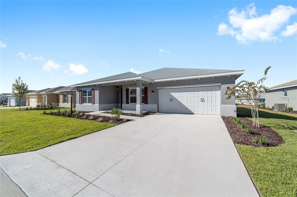 A single-story house with a gray exterior, a two-car garage, and a concrete driveway — 10019 SW 106TH CIRCLE, OCALA, FL