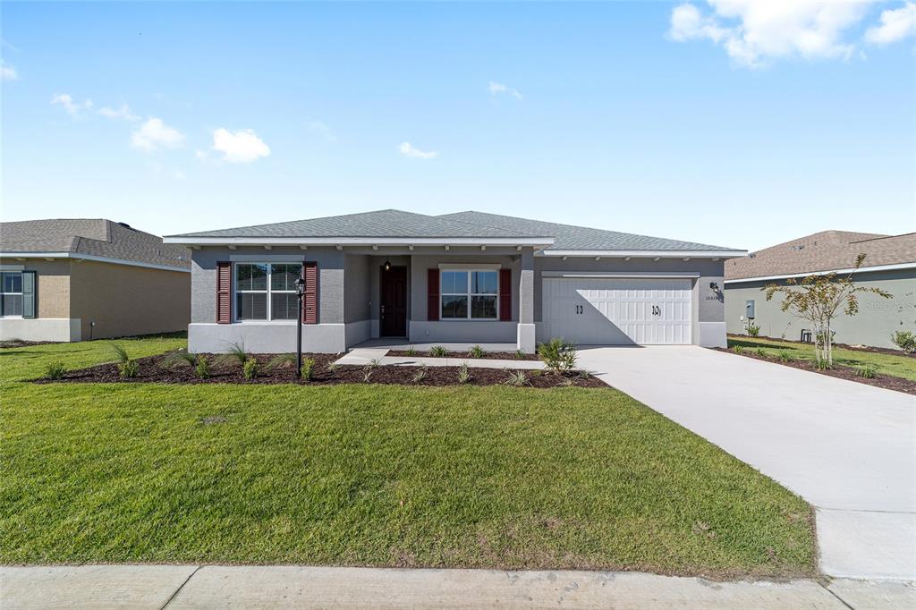 A single-story gray house with a two-car garage and a front lawn — 10019 SW 106TH CIRCLE, OCALA, FL