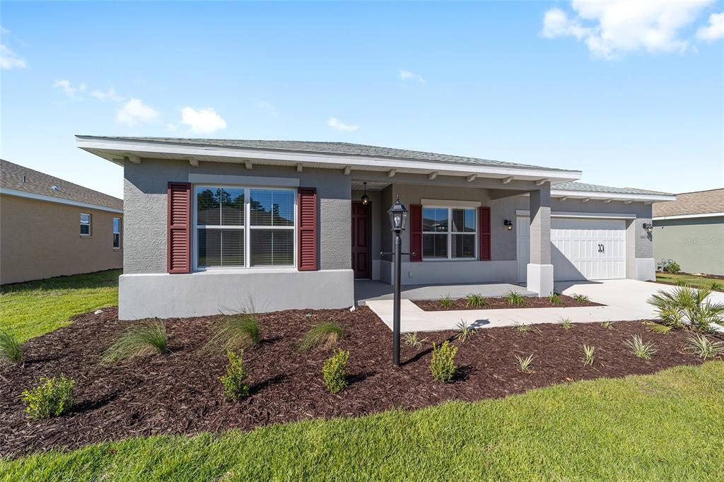 A single-story house with a gray stucco exterior, red shutters, and a two-car garage — 10019 SW 106TH CIRCLE, OCALA, FL