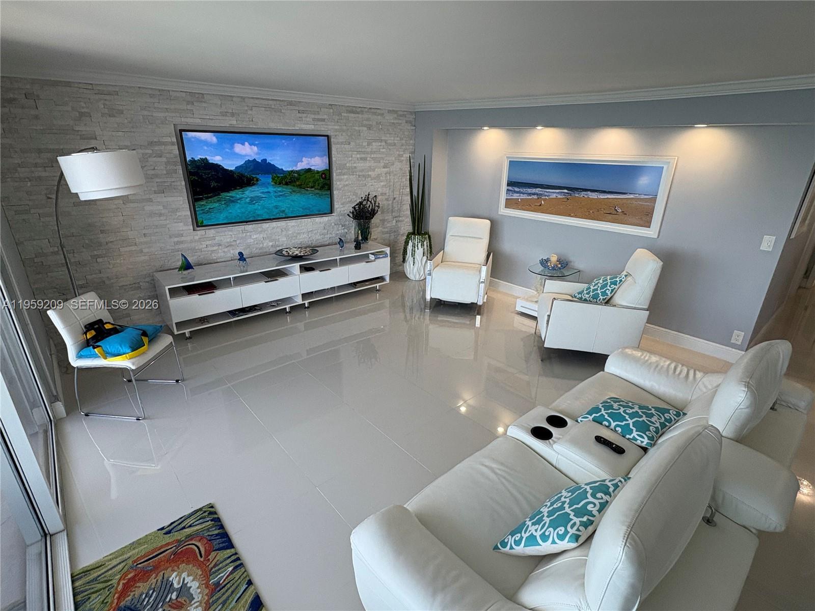 A modern living room features white leather furniture, a stone accent wall, and glossy tile floors — 2030 S Ocean Dr # 1812, Hallandale Beach FL 33009, HALLANDALE BEACH, FL