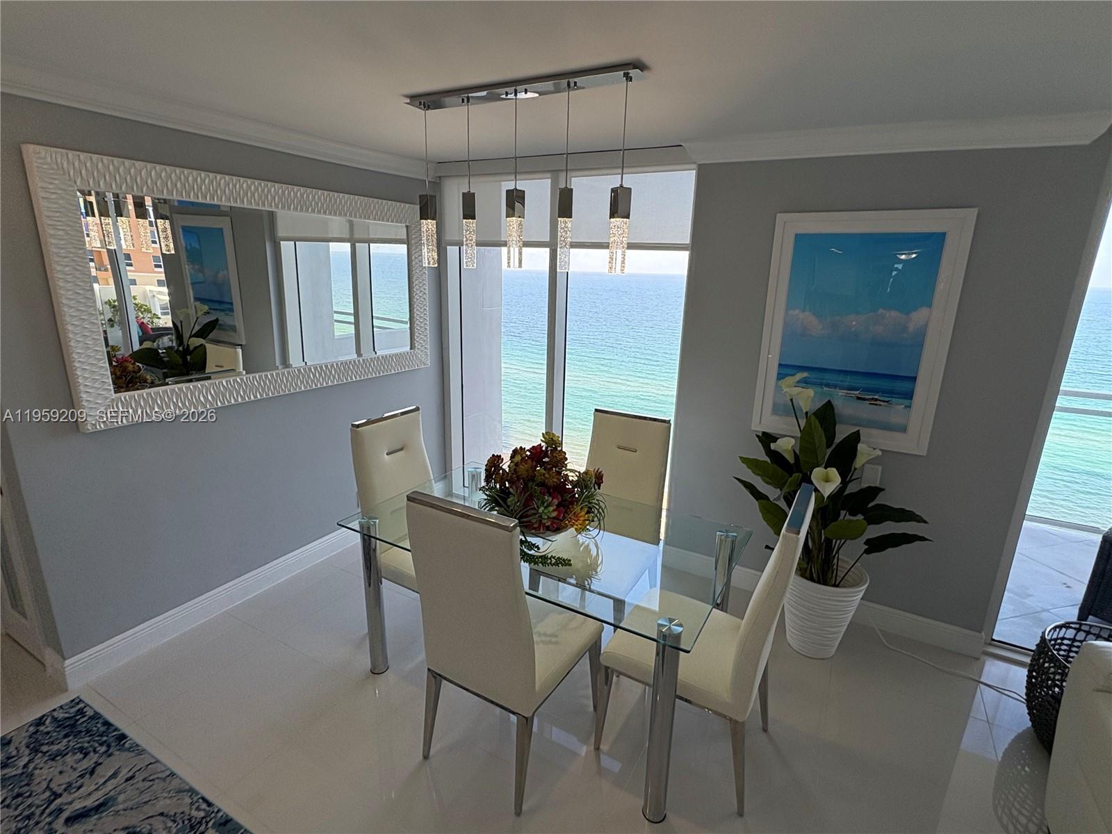 A dining room features a glass table, four white chairs, and an ocean view — 2030 S Ocean Dr # 1812, Hallandale Beach FL 33009, HALLANDALE BEACH, FL