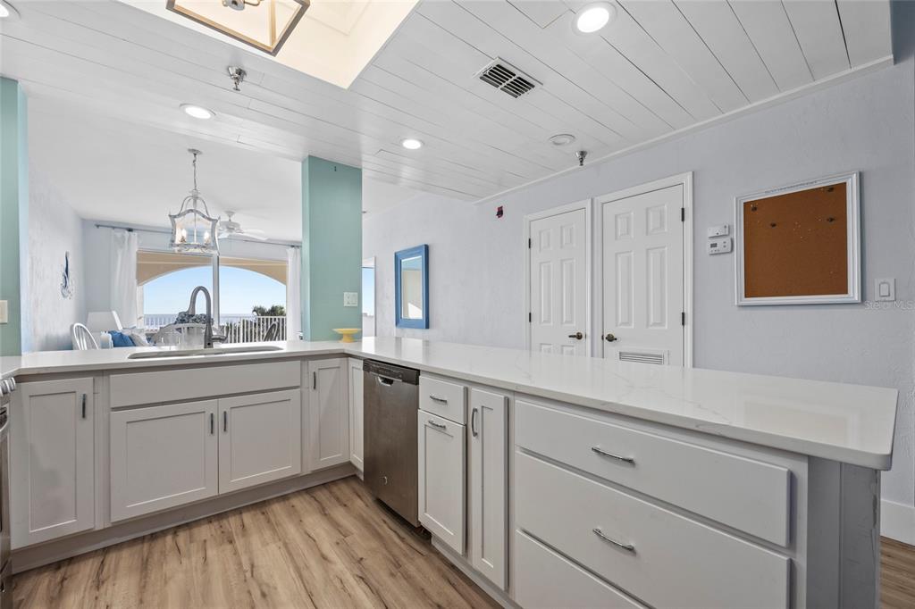 A kitchen with white cabinets, quartz countertops, and a view of the ocean — 104 SURFVIEW DRIVE UNIT 2203, PALM COAST, FL