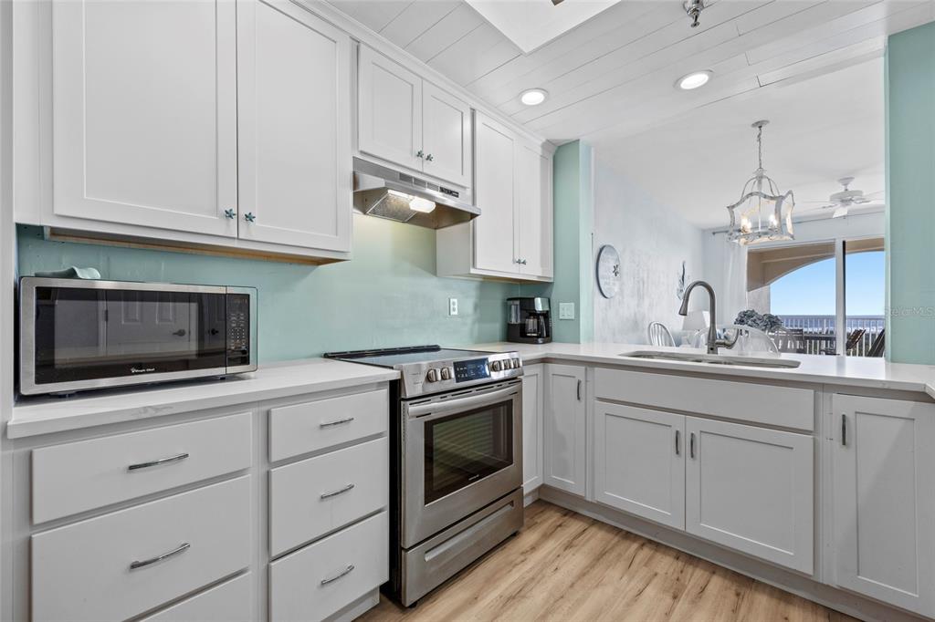 A kitchen with white cabinets, stainless steel appliances, and light blue walls — 104 SURFVIEW DRIVE UNIT 2203, PALM COAST, FL