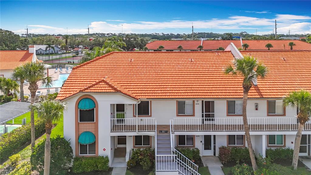 An exterior view of a two-story apartment building with a red tile roof and balconies — 4382 MADEIRA COURT UNIT 3361, SARASOTA, FL