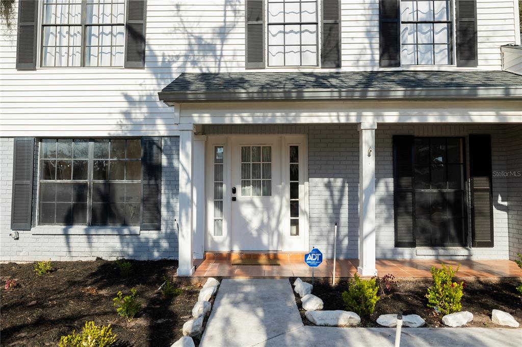 A two-story house exterior features white siding, gray brick, black shutters, and a front porch — 3728 MURRAY DALE DRIVE, VALRICO, FL