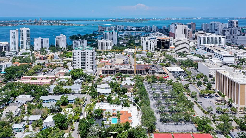 An aerial view shows a multi-story building with a pool, surrounded by urban development — 1685 LAUREL STREET UNIT 3, SARASOTA, FL