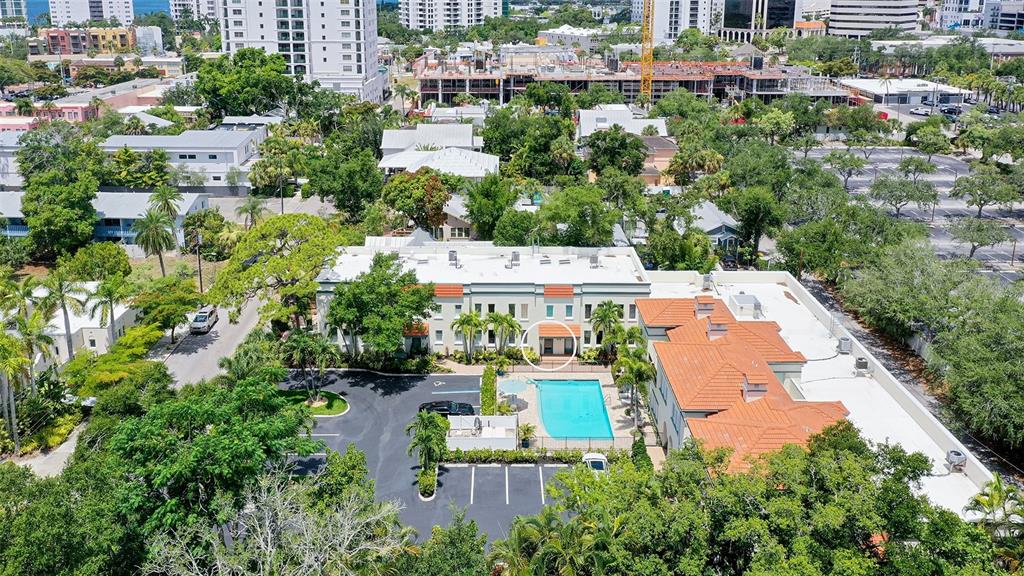 An aerial view shows a multi-story apartment building with a swimming pool and parking lot — 1685 LAUREL STREET UNIT 3, SARASOTA, FL