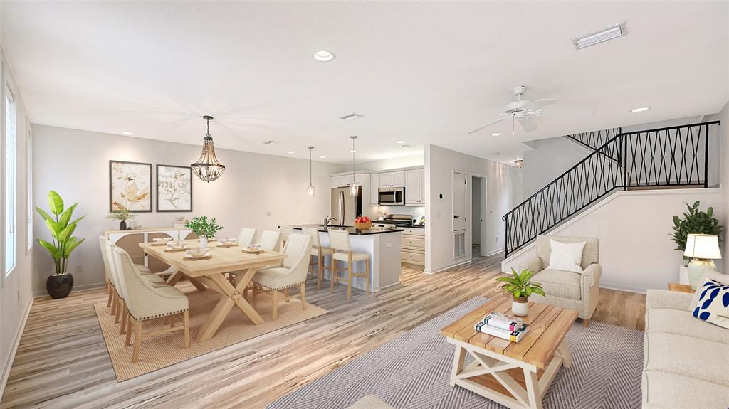 An open-concept living and dining area features light wood flooring, a kitchen island, and stairs — 1685 LAUREL STREET UNIT 3, SARASOTA, FL