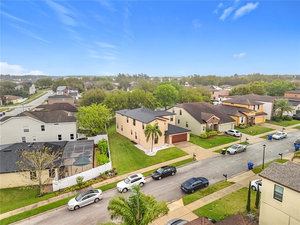 An aerial view shows suburban houses with driveways, parked cars, and green lawns — 319 ARBOR POINTE AVENUE, MINNEOLA, FL