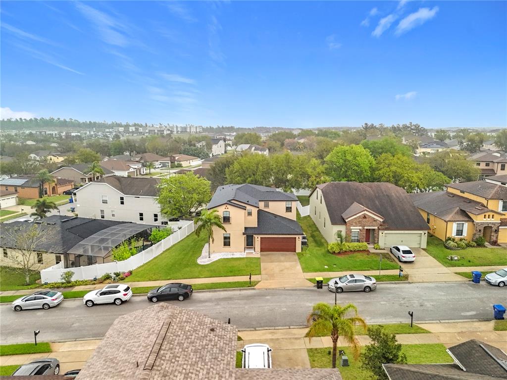 An aerial view shows a suburban street with houses, driveways, and parked cars — 319 ARBOR POINTE AVENUE, MINNEOLA, FL