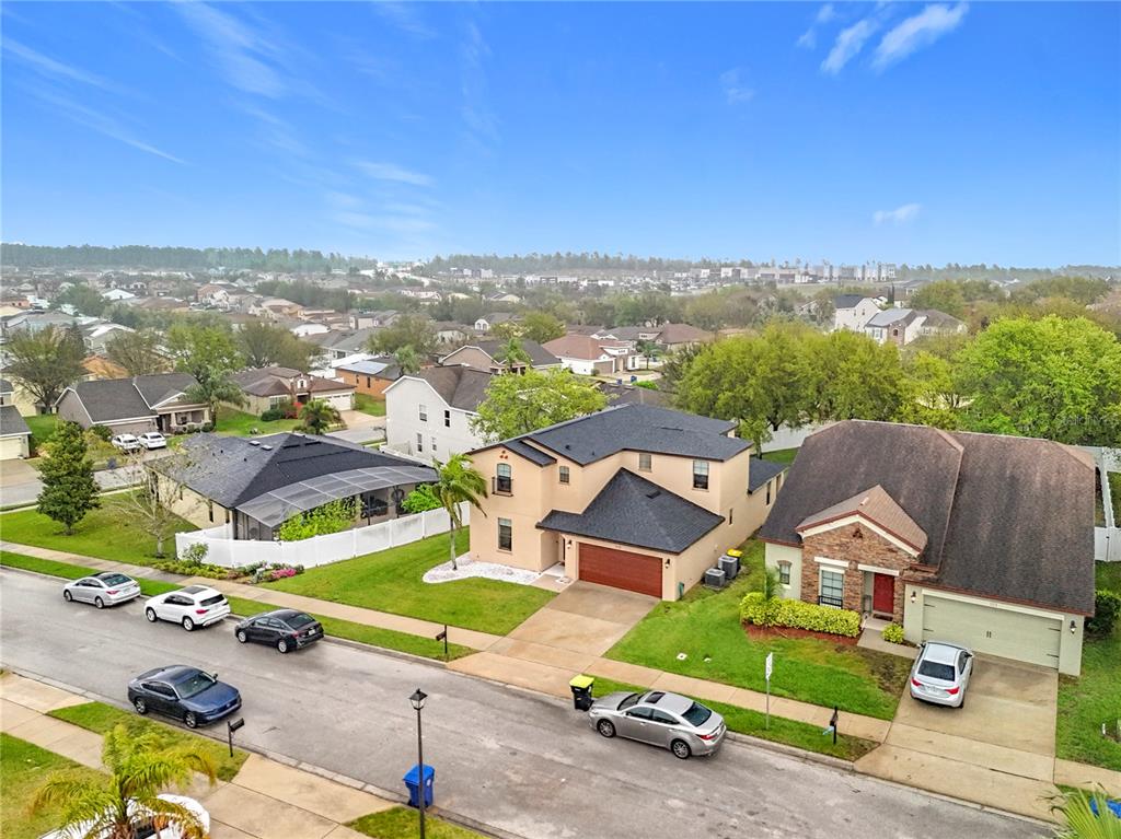 An aerial view shows suburban houses with driveways and parked cars on a residential street — 319 ARBOR POINTE AVENUE, MINNEOLA, FL