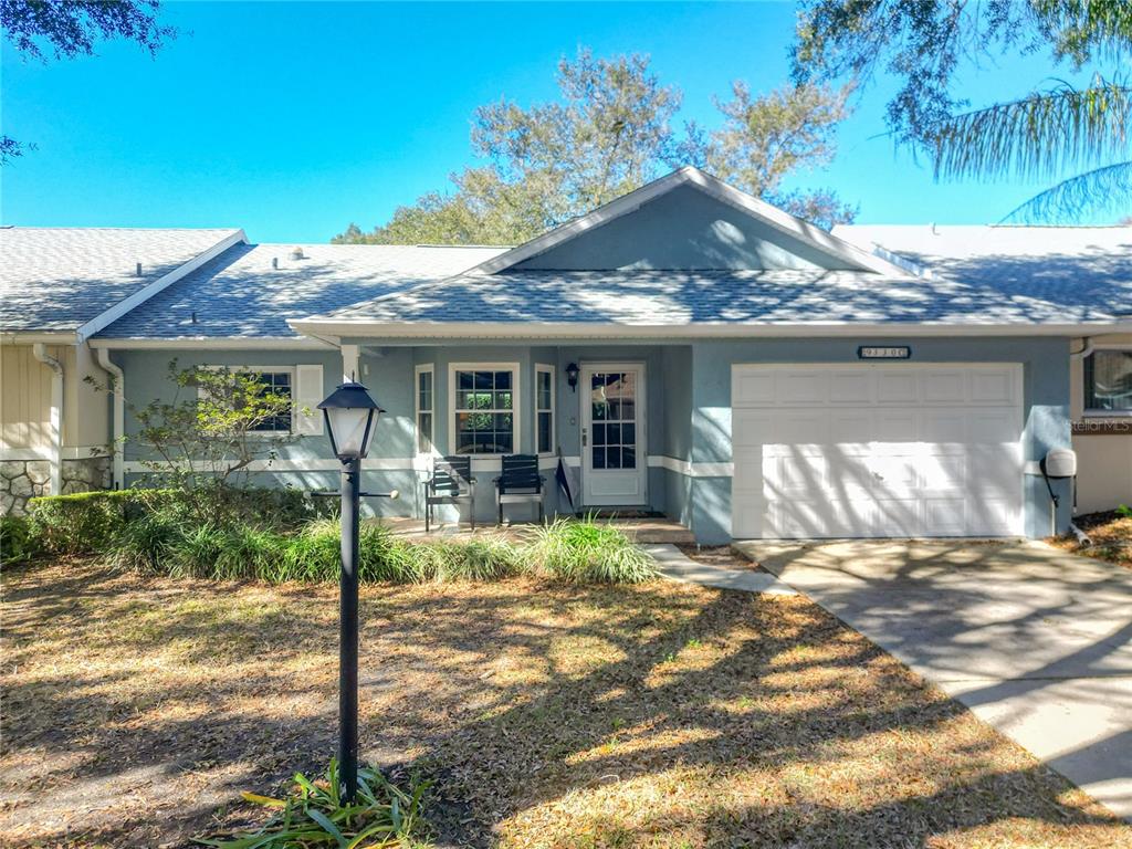 A single-story house with a blue exterior, a white garage door, and a front porch — 9330 SW 84TH TERRACE UNIT C, OCALA, FL