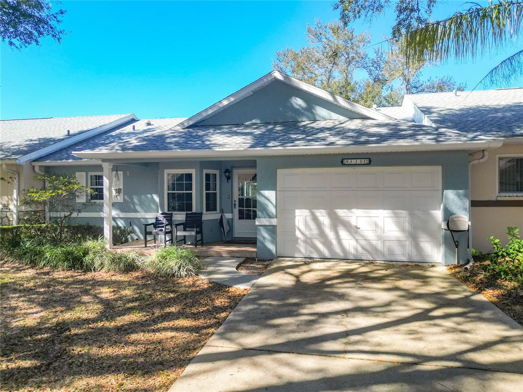 A light blue single-story house with a white garage door and a covered front porch — 9330 SW 84TH TERRACE UNIT C, OCALA, FL