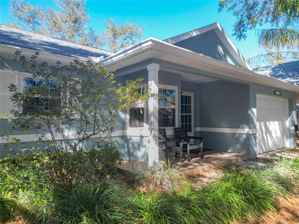 A blue single-story house with a covered front porch, white trim, and a garage — 9330 SW 84TH TERRACE UNIT C, OCALA, FL