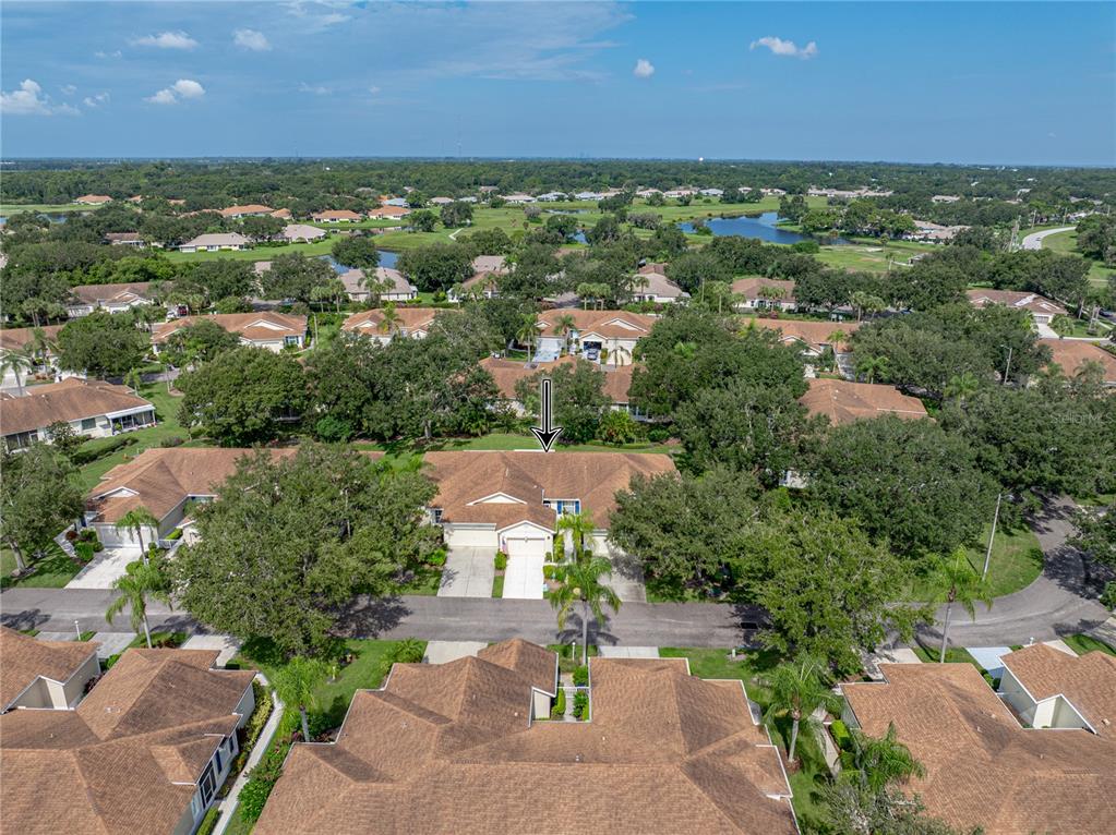 An aerial view shows a residential neighborhood with single-story homes and surrounding green space — 2344 NANTUCKET DRIVE UNIT 59, SUN CITY CENTER, FL