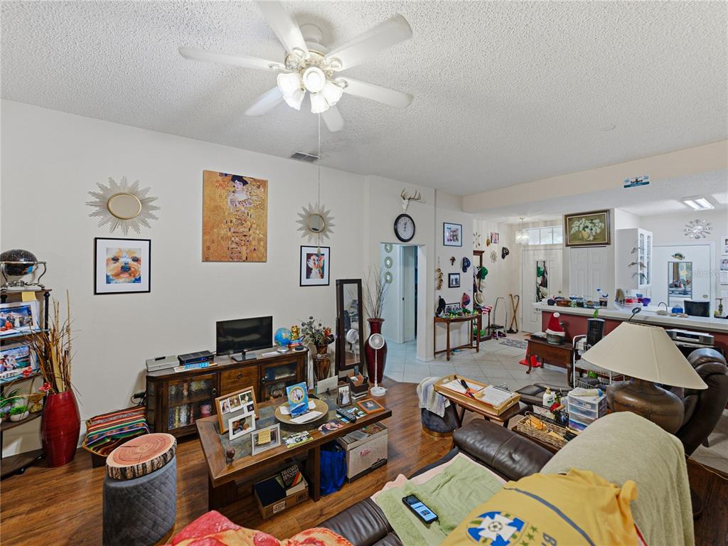 A living room features a ceiling fan, wood-look flooring, and a coffee table — 2344 NANTUCKET DRIVE UNIT 59, SUN CITY CENTER, FL