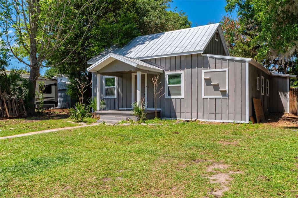 A gray, single-story house with a metal roof and a small front porch — 714 WYOMING AVENUE, ST CLOUD, FL