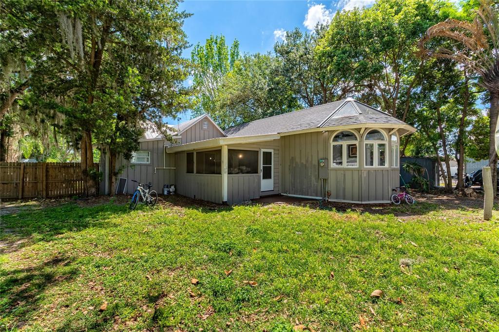The exterior of a single-story house features a screened porch and a bay window — 714 WYOMING AVENUE, ST CLOUD, FL