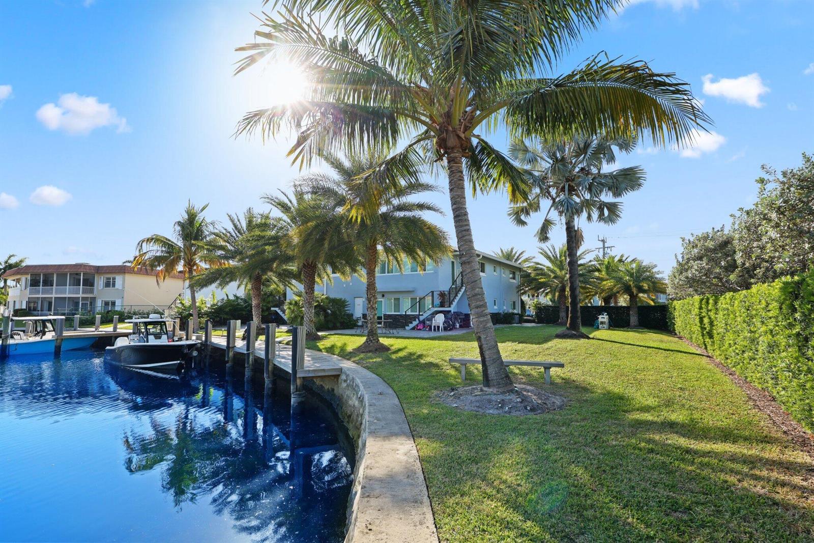 A blue house sits beside a canal with a boat dock and palm trees — 830 SE 22nd Avenue, Pompano Beach FL 33062, POMPANO BEACH, FL