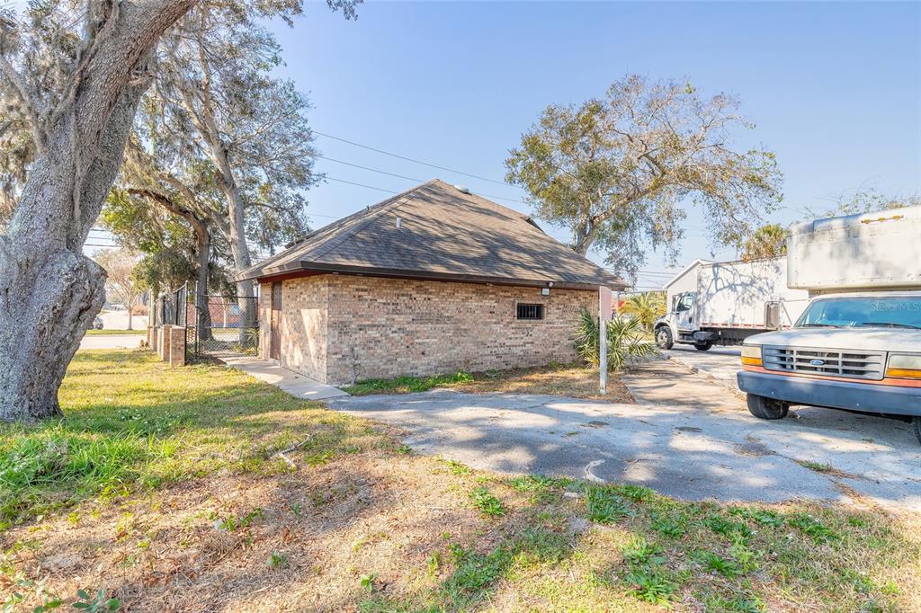 A single-story brick building with a hip roof sits on a paved lot with trees — 631 N RIDGEWOOD AVENUE, DAYTONA BEACH, FL