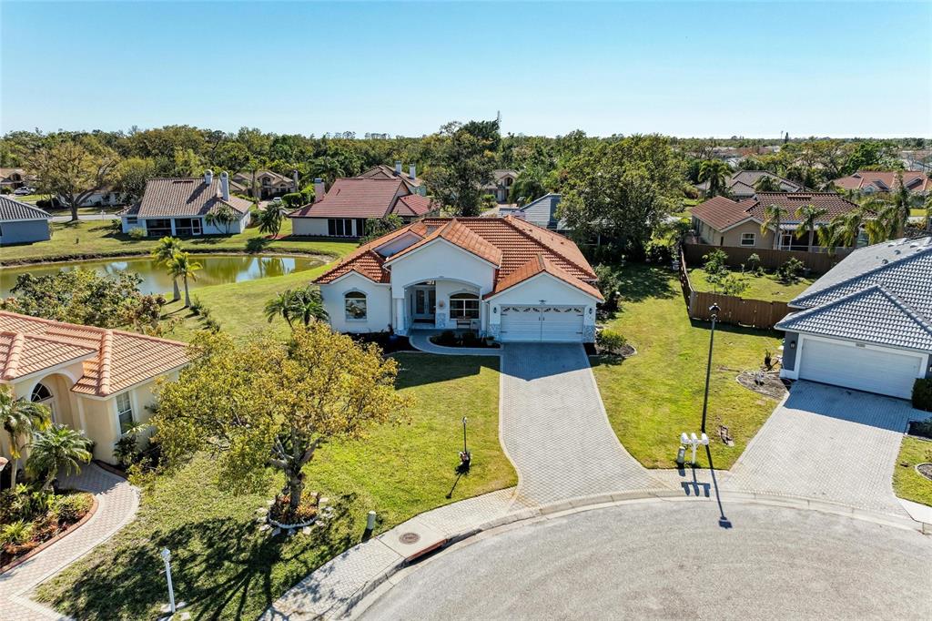 An aerial view shows a single-story house with a tiled roof and a paved driveway — 7102 42ND COURT E, SARASOTA, FL