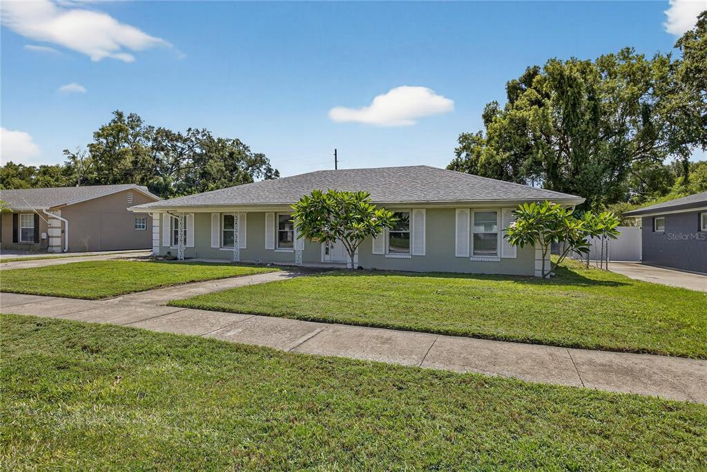 A single-story house with a light green exterior, white shutters, and a gray shingled roof — 2502 VINE STREET, ORLANDO, FL