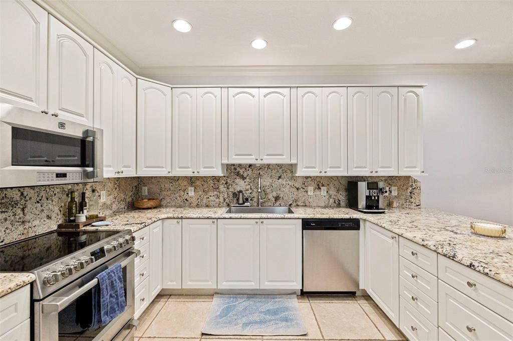 A kitchen with white cabinets, granite countertops, stainless steel appliances, and tile flooring — 123 VALENCIA CIRCLE, ST PETERSBURG, FL