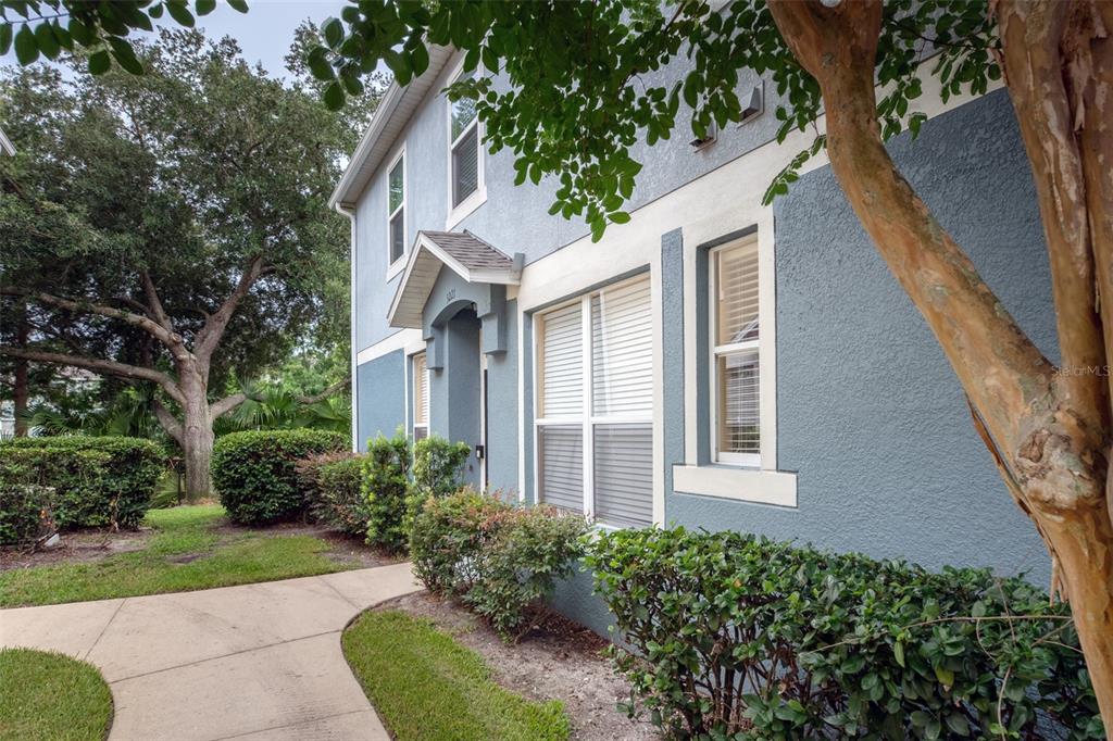 A blue two-story building exterior features a concrete walkway, manicured shrubs, and large windows — 3221 SAN JACINTO CIRCLE UNIT 3221, SANFORD, FL