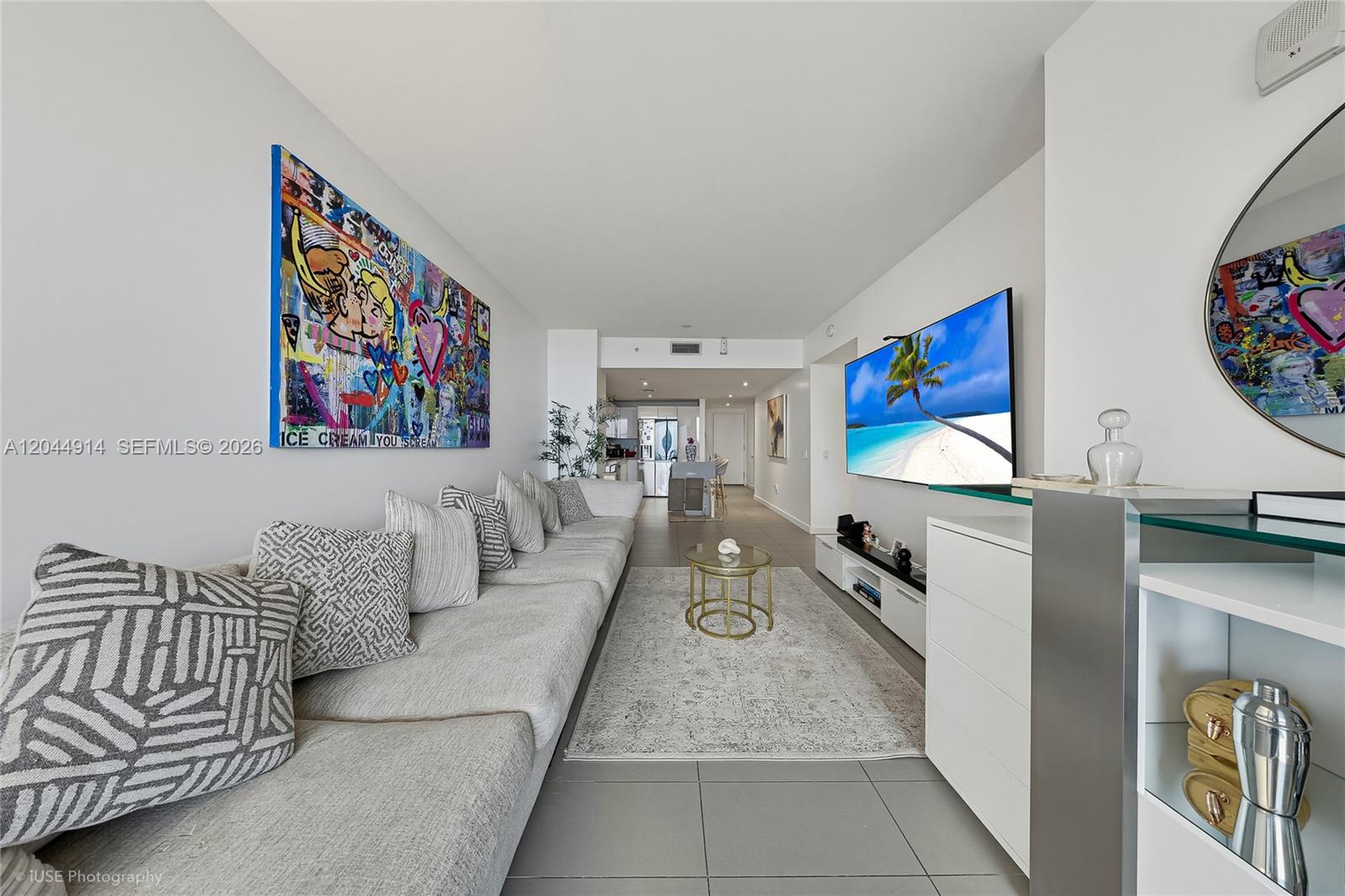 A modern living room features a large gray sectional sofa, wall art, and a television — 1600 NE 1st Ave # 2814, Miami FL 33132, MIAMI, FL