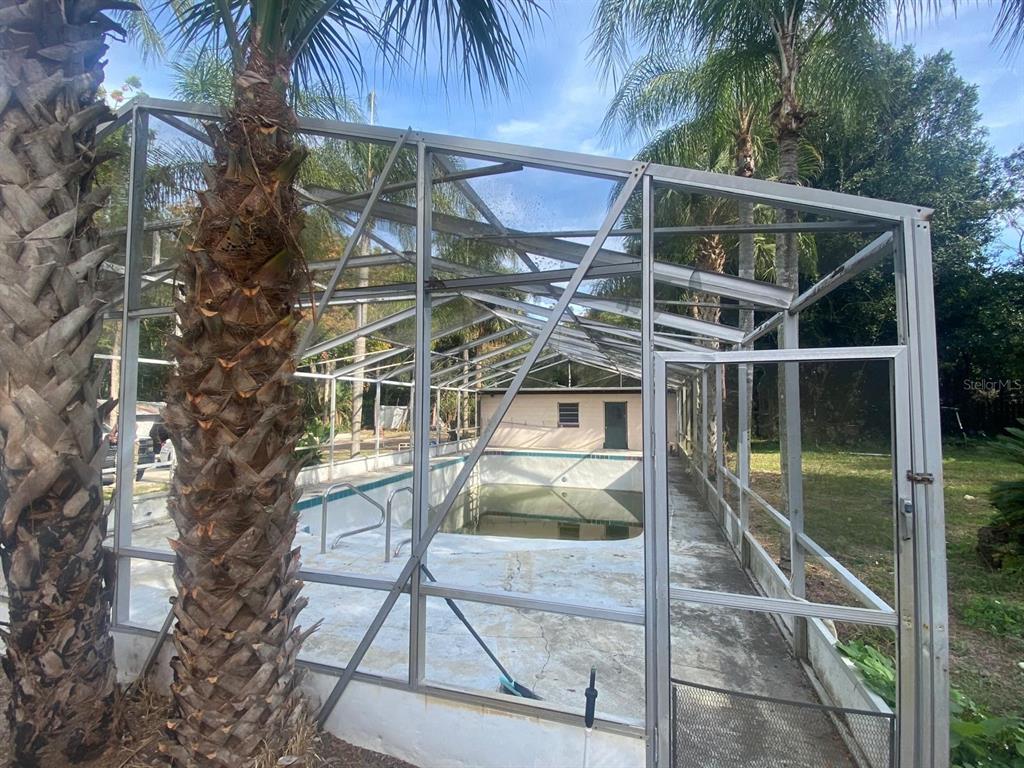 A single-story house with a gray exterior, a concrete driveway, and a fenced-in porch area — 4327 PLYMOUTH SORRENTO ROAD, APOPKA, FL