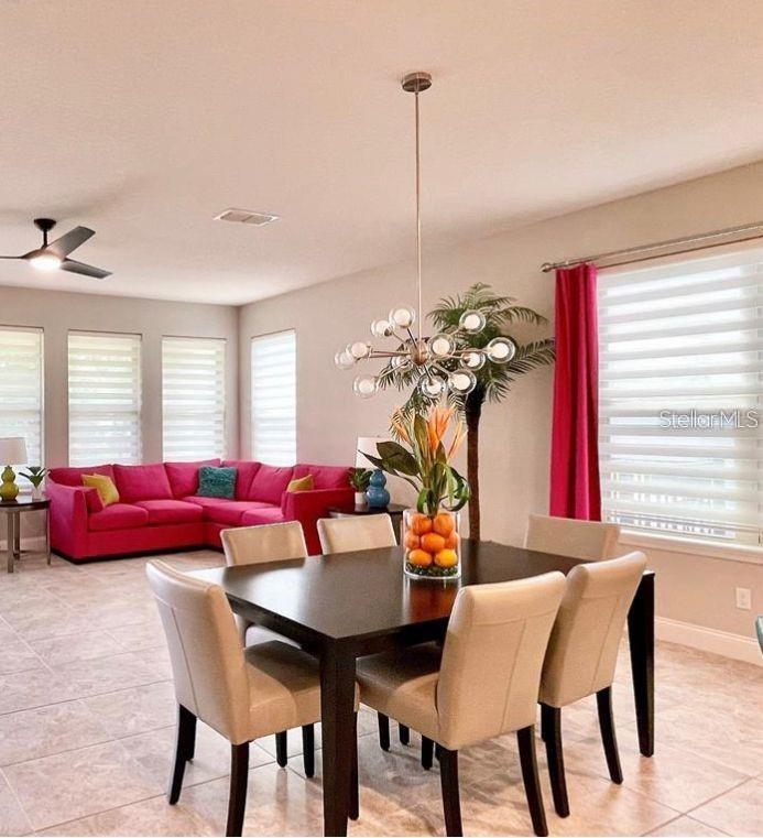 A dining area and kitchen feature white cabinetry, a large island, and light wood flooring — 13542 GORGONA ISLE DRIVE, WINDERMERE, FL