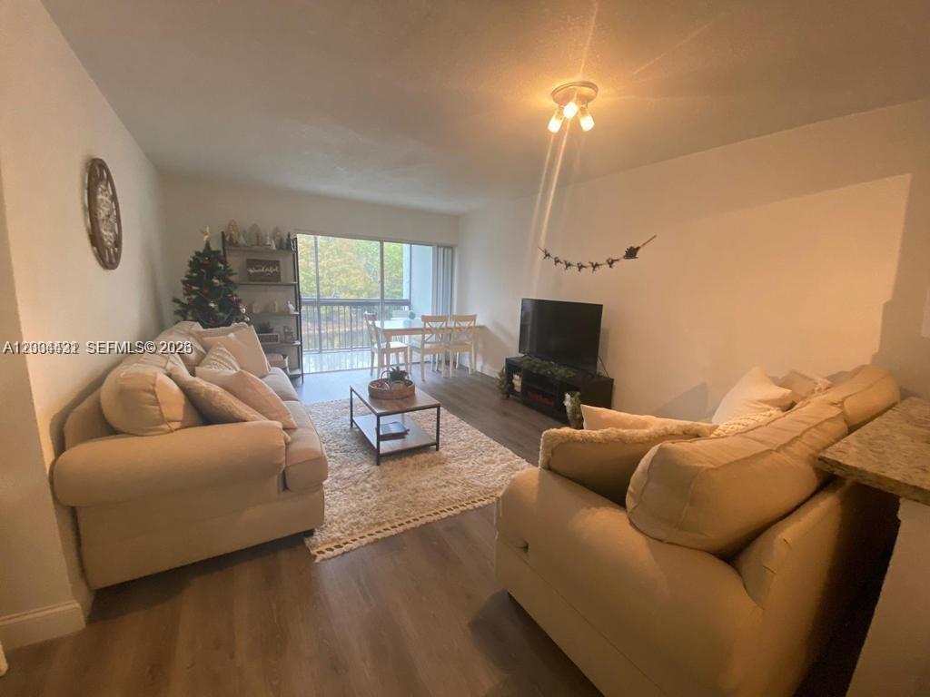 A living room features two beige sofas, a coffee table, and a dining area — PLANTATION, FL