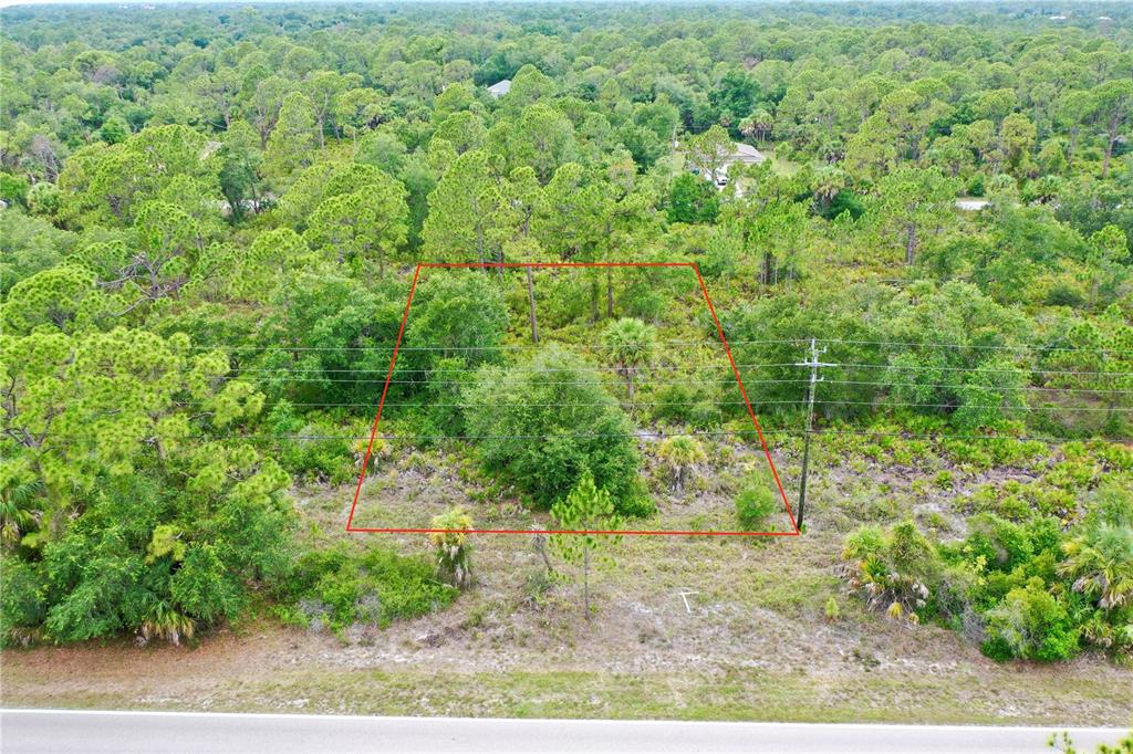 An aerial view shows a rectangular plot of land outlined in red near a road — 3129 COLLINGSWOOD BOULEVARD, PORT CHARLOTTE, FL