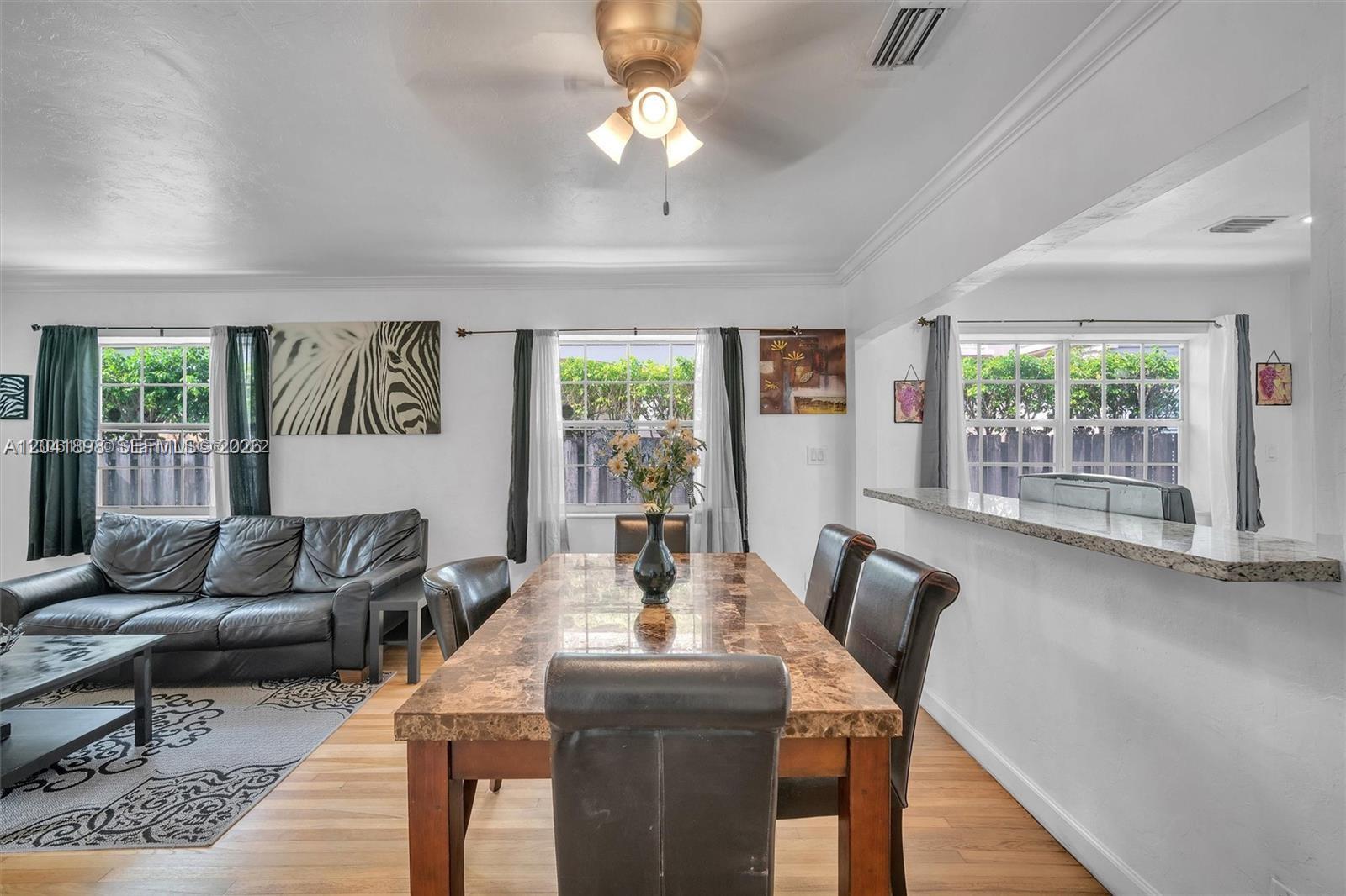 A dining area with a marble-topped table sits adjacent to a living room with leather furniture — 1635 Hollywood Blvd, Hollywood FL 33020, HOLLYWOOD, FL