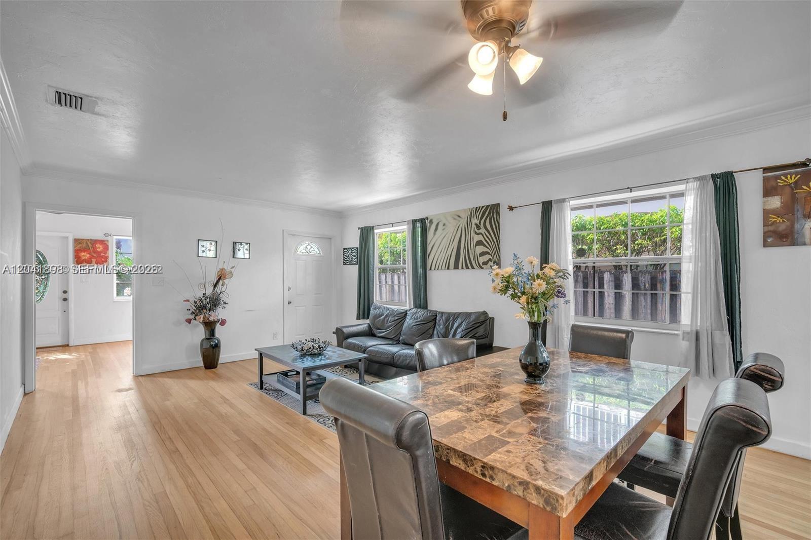 A living and dining area features hardwood floors, a marble-topped table, and a leather sofa — 1635 Hollywood Blvd, Hollywood FL 33020, HOLLYWOOD, FL