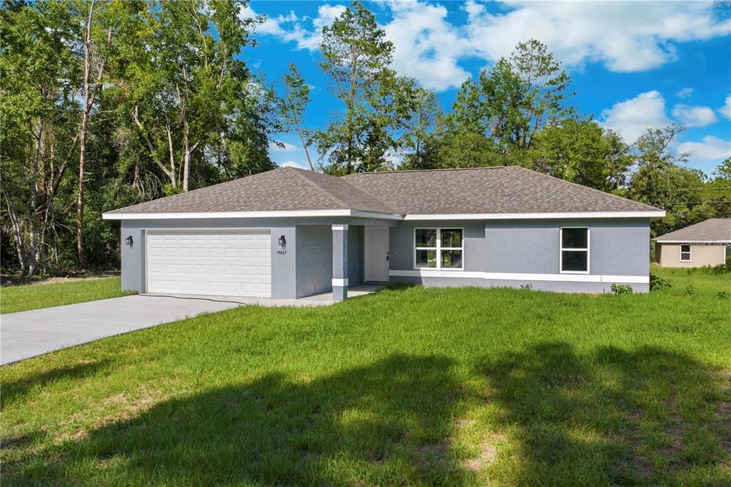 A single-story gray house with a two-car garage and a grassy front yard — 2512 SW 147TH PLACE ROAD, OCALA, FL