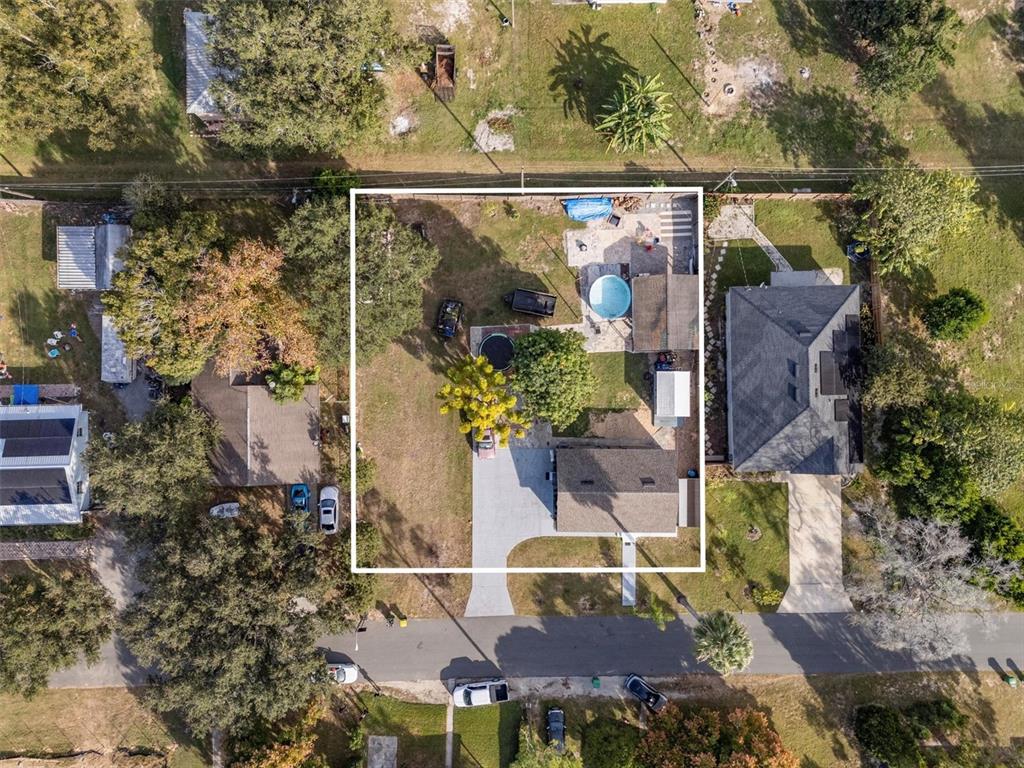 An aerial view shows a residential property with a house, pool, and large backyard — 513 5TH STREET, DUNDEE, FL