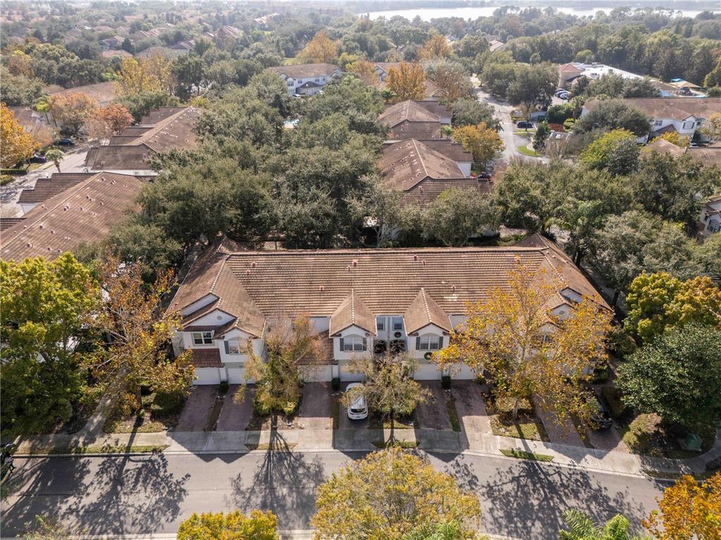 An aerial view shows a multi-unit townhouse building with brown tile roofs and driveways — 6979 SPERONE STREET, ORLANDO, FL