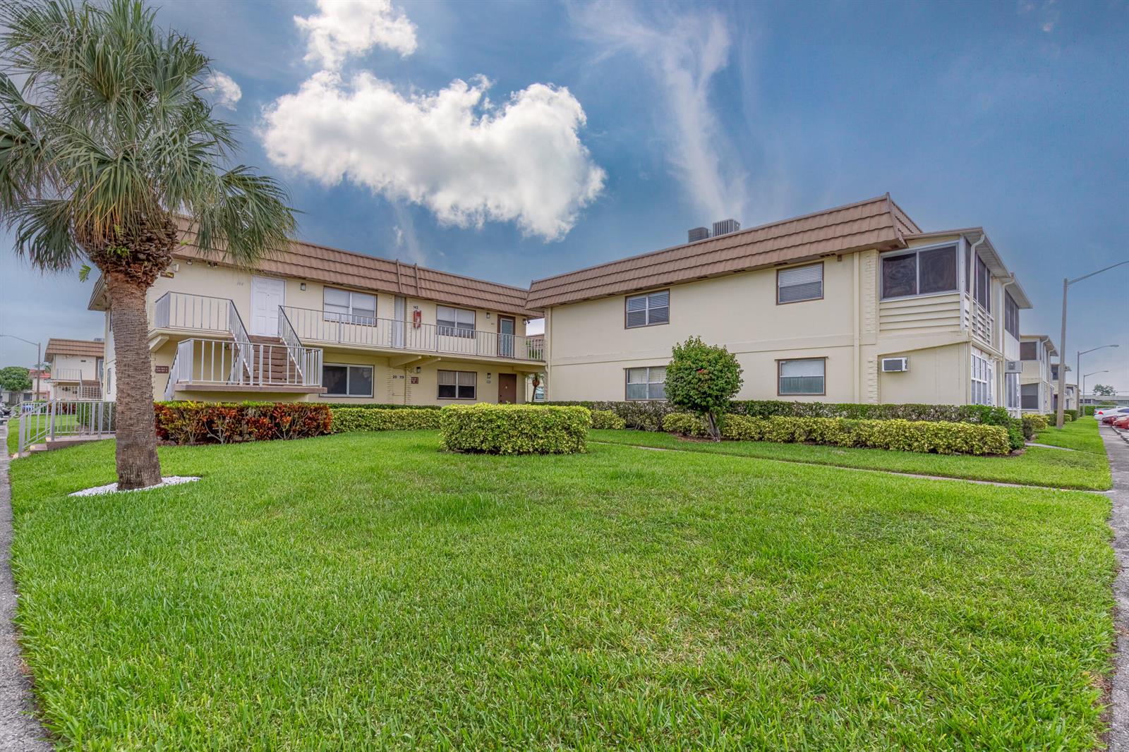 A two-story apartment building with a palm tree and a manicured lawn in front — 141 Saxony C Terrace # 141, Delray Beach FL 33446, DELRAY BEACH, FL