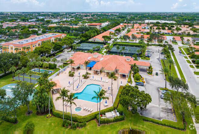 An aerial view shows a community clubhouse with a swimming pool, tennis courts, and parking — 141 Saxony C Terrace # 141, Delray Beach FL 33446, DELRAY BEACH, FL