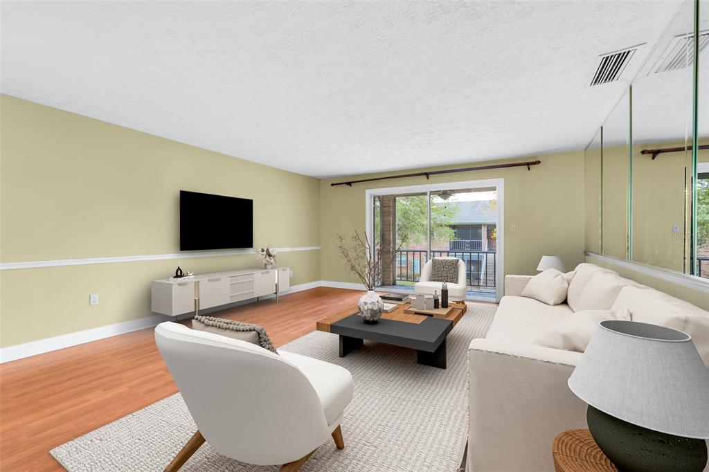 A living room features light green walls, a white sofa, two armchairs, and mirrored walls — 4224 LAKE UNDERHILL ROAD UNIT 8B8, ORLANDO, FL