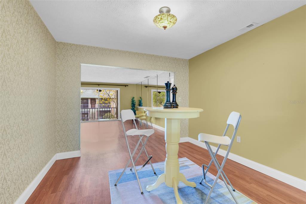 A dining area features a pedestal table, two folding chairs, and a sliding glass door — 4224 LAKE UNDERHILL ROAD UNIT 8B8, ORLANDO, FL