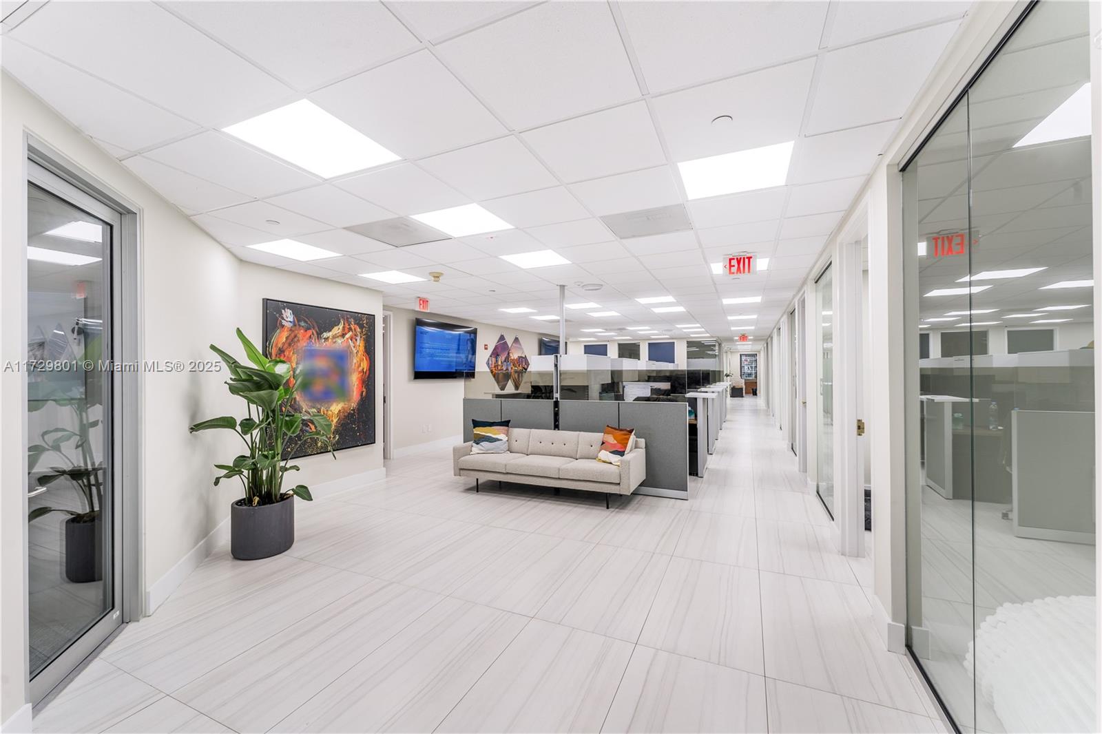 A modern office interior features a waiting area with a sofa, cubicles, and tile flooring — 1200 Brickell Ave # A, Miami FL 33131, MIAMI, FL