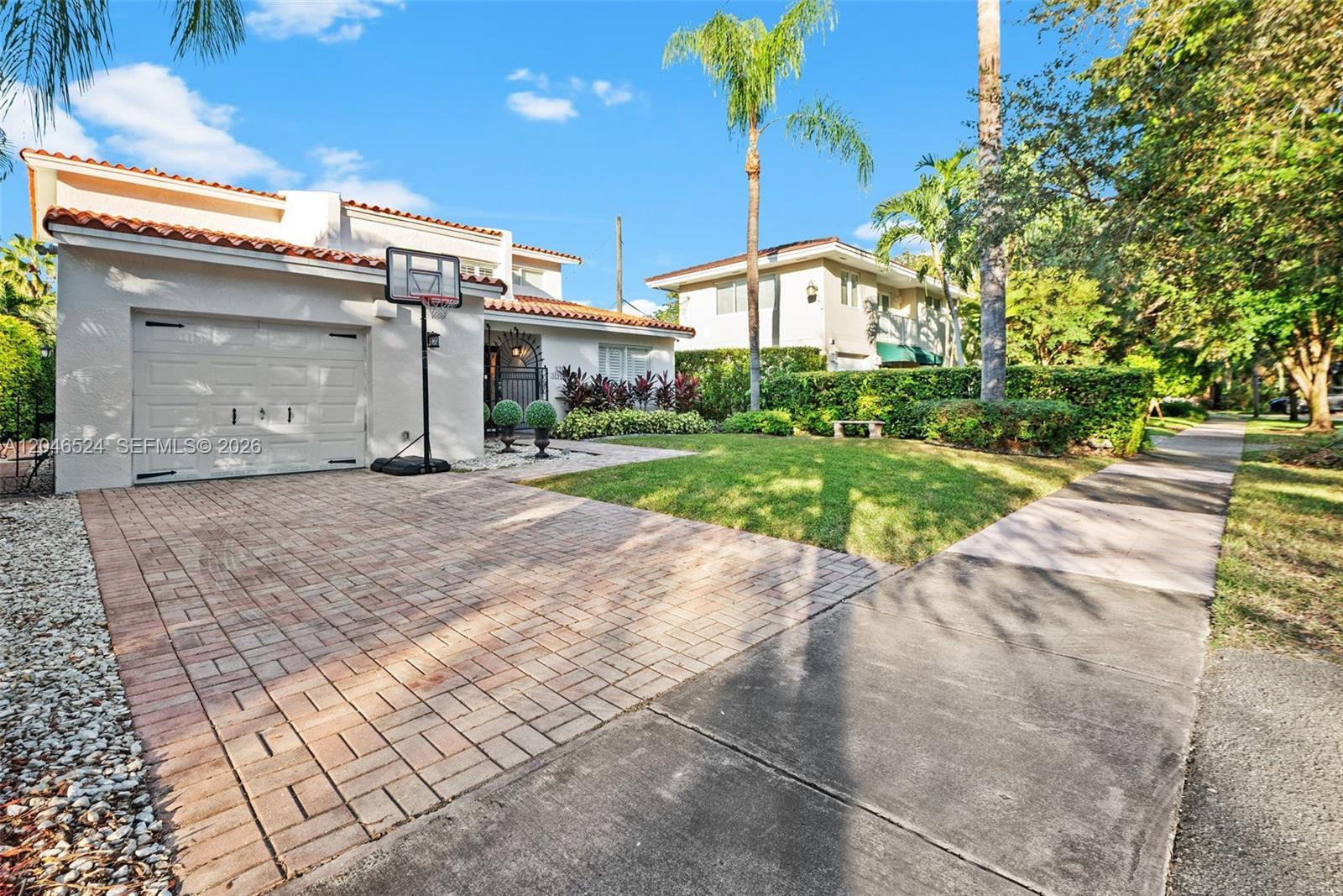 A two-story house with a brick driveway, basketball hoop, and a front lawn — 1211 Algeria Ave, Coral Gables FL 33134, CORAL GABLES, FL