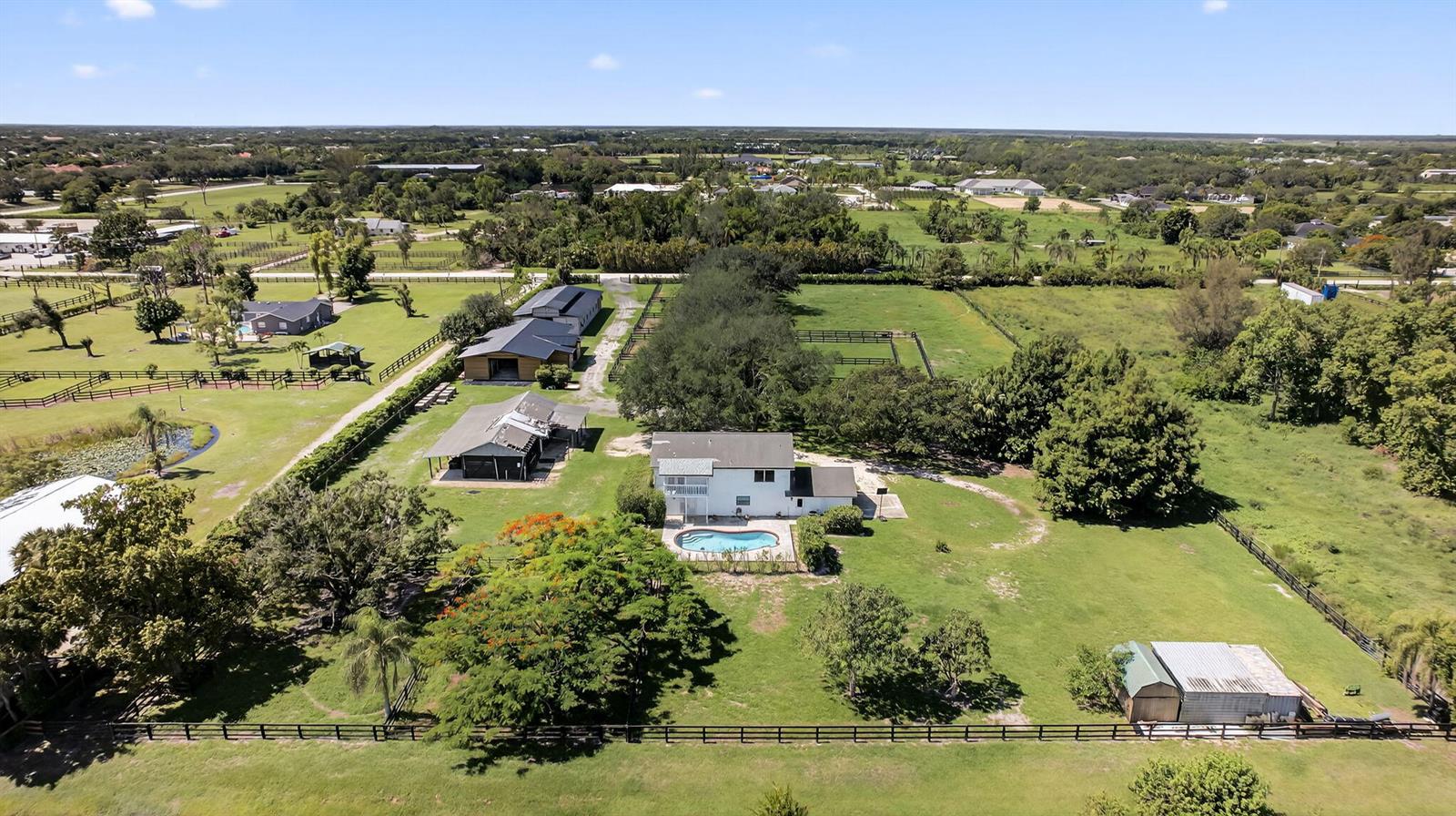 An aerial view shows a rural property with a house, pool, and several outbuildings — 16229 Rustic Rd Road, Wellington FL 33470, WELLINGTON, FL