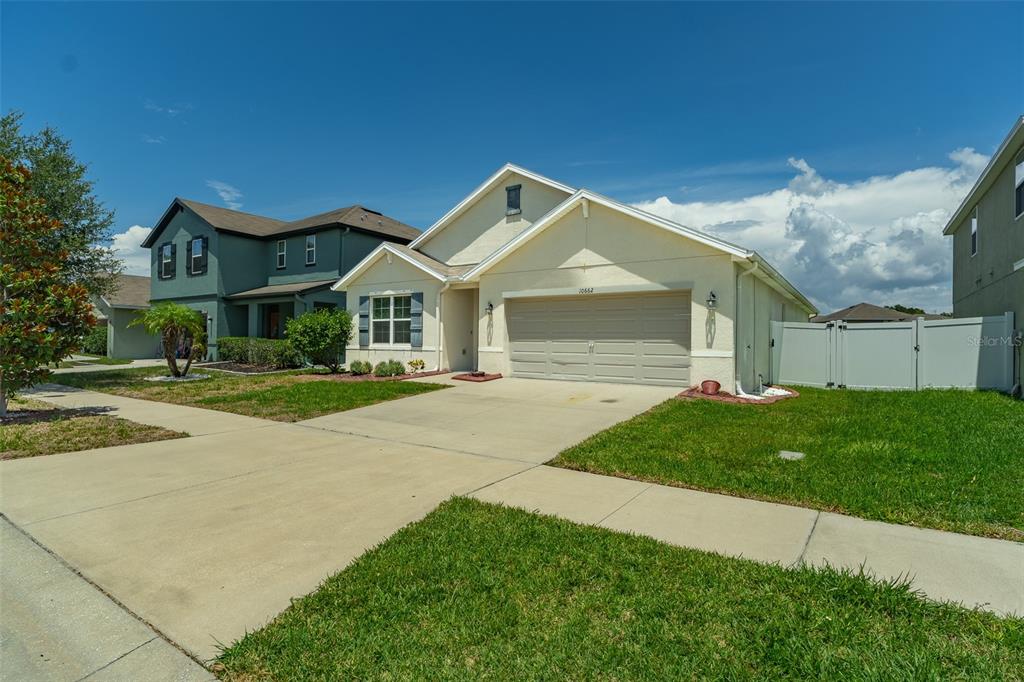 A light-colored single-story house with a two-car garage and a concrete driveway — 10662 PARK MEADOWBROOKE DRIVE, RIVERVIEW, FL