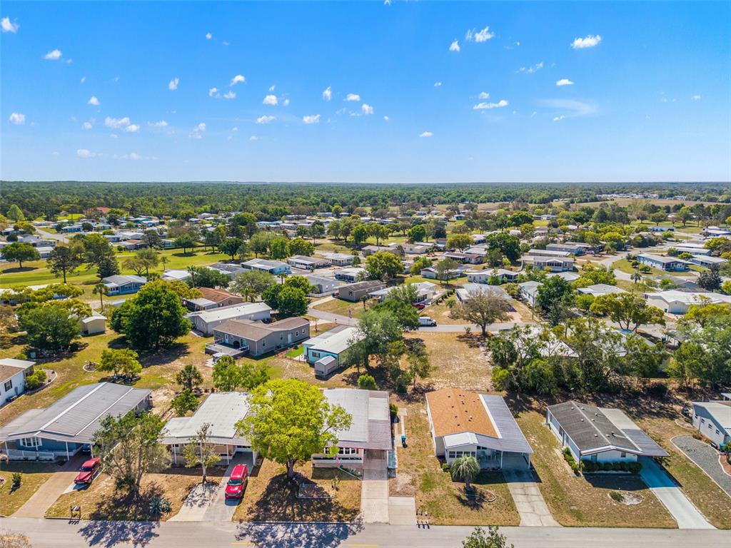 An aerial view shows a residential neighborhood with several manufactured homes and surrounding trees — 15110 RIALTO AVENUE, BROOKSVILLE, FL